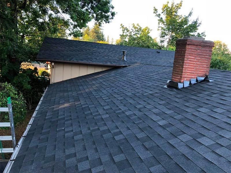Modern home with 21-inch grey standing seam metal roof panels and brick exterior
