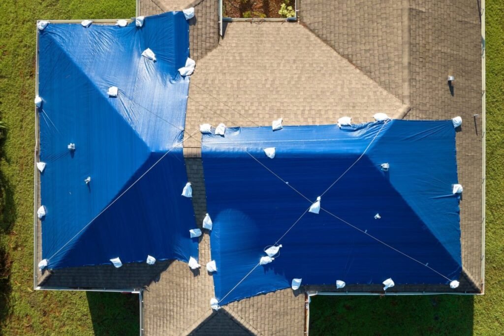 Aerial view of home roof covered with blue emergency tarps in Vancouver, WA