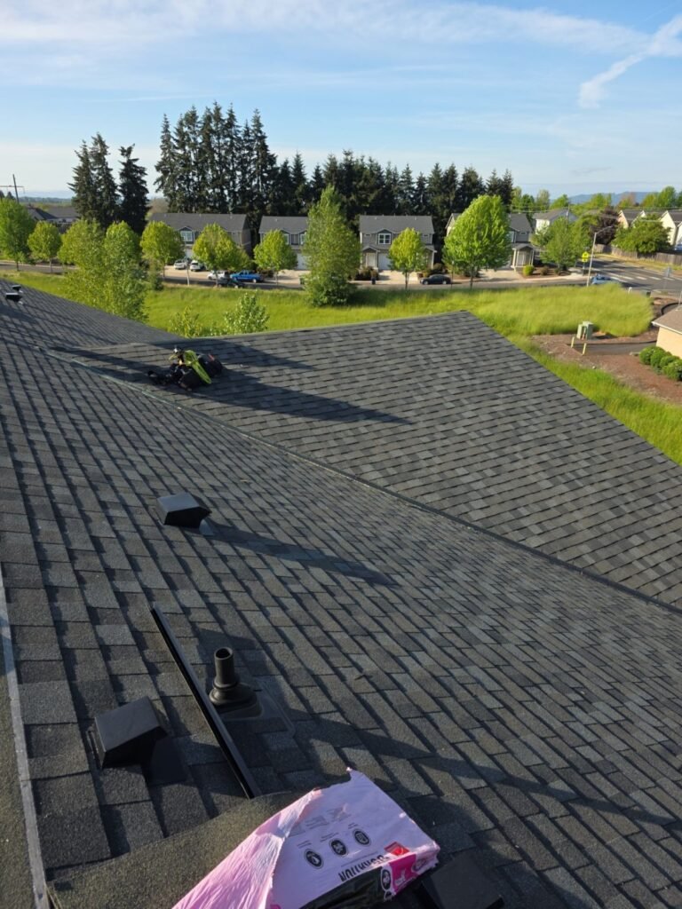 View from asphalt shingle roof with materials, overlooking Portland Oregon neighborhood